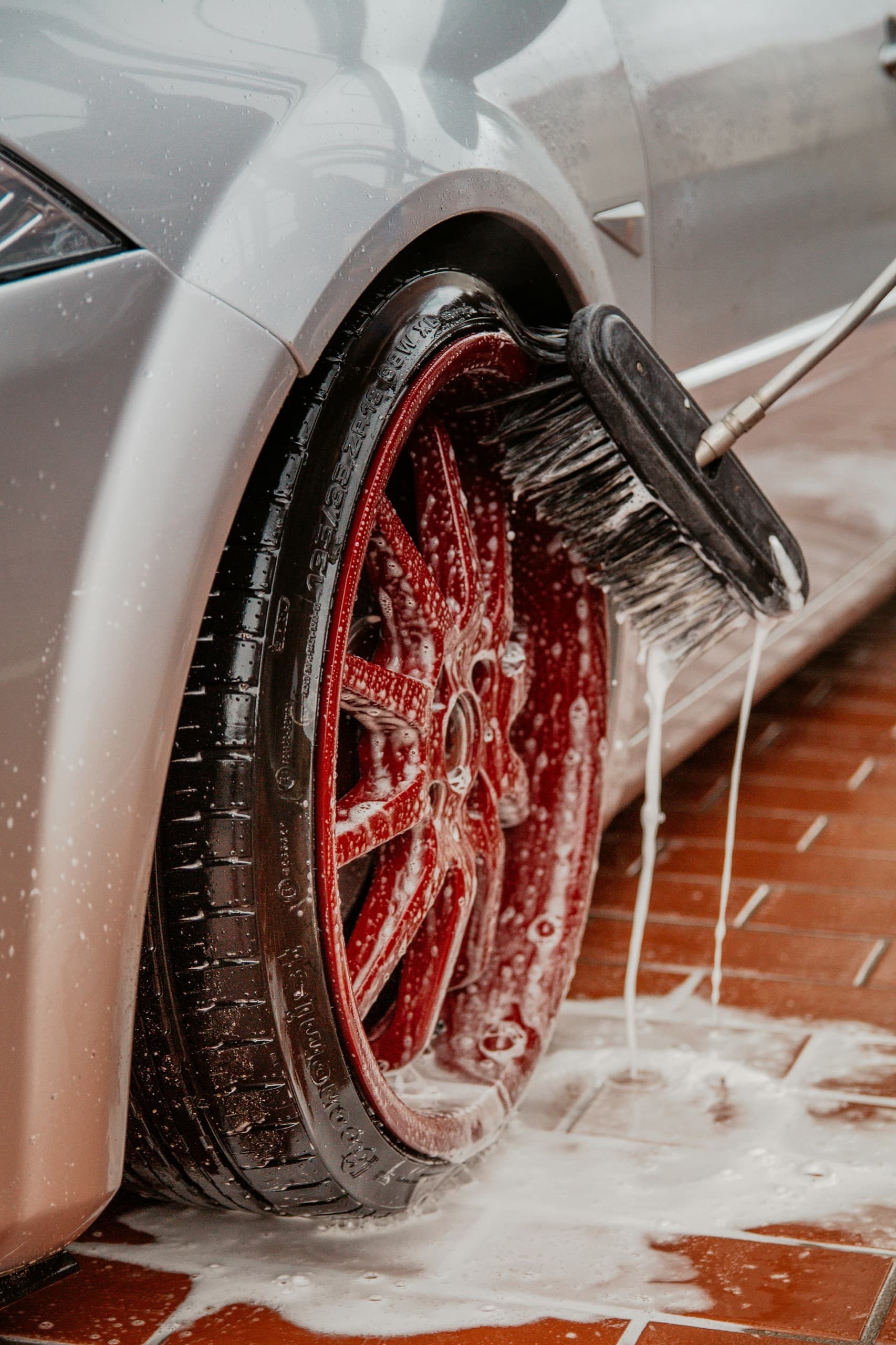 Detailer vacuuming and wiping down a car interior during The Daily Gleam